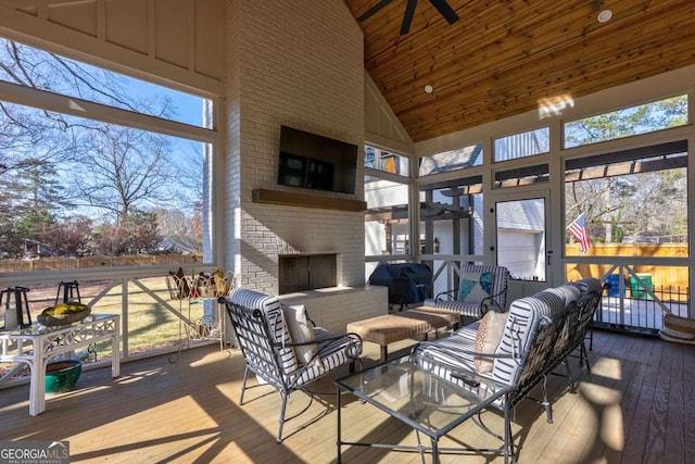 sunroom / solarium with an outdoor living space with a fireplace and a ceiling fan