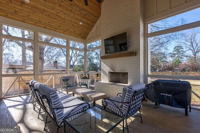 sunroom / solarium featuring an outdoor living space with a fireplace and a wealth of natural light