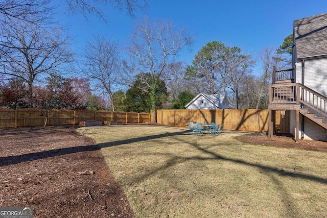 view of yard with a fenced backyard and stairs