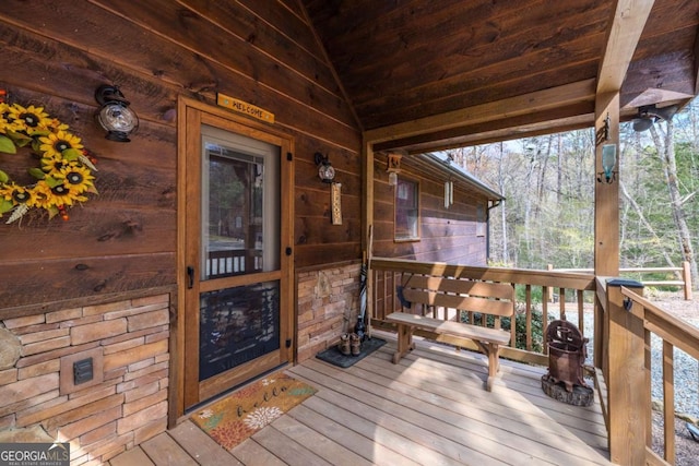 living room with wood walls, ceiling fan, wood ceiling, high vaulted ceiling, and wood-type flooring