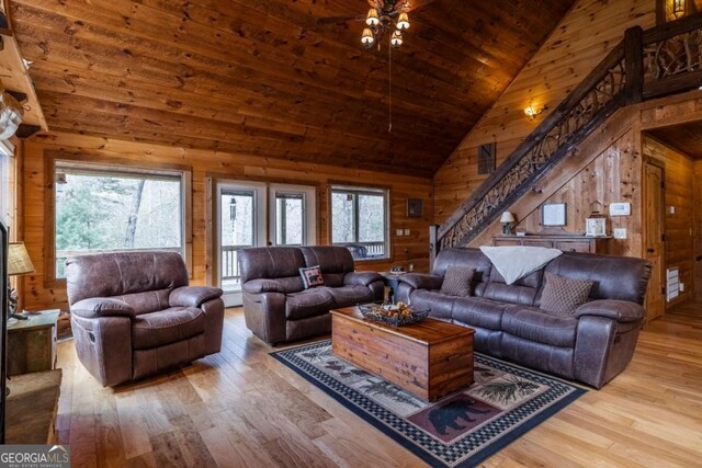 living area with high vaulted ceiling, hardwood / wood-style floors, wood walls, and wood ceiling