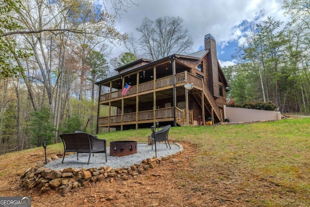 view of side of home with stairway, a wooded view, a chimney, driveway, and covered porch