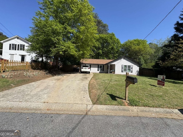 single story home featuring a front lawn, fence, and concrete driveway