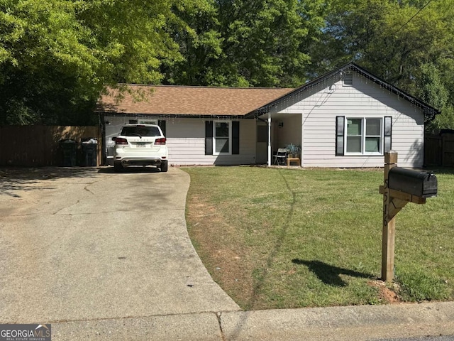 single story home with a shingled roof, concrete driveway, a front yard, and fence