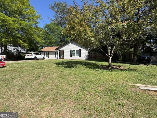 view of front of home featuring a front lawn and fence