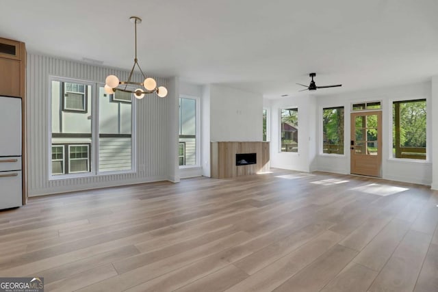 644 Glendale Rd, Scottdale, GA 30079 - unfurnished living room with a fireplace, light wood-style flooring, ceiling fan with notable chandelier, and baseboards