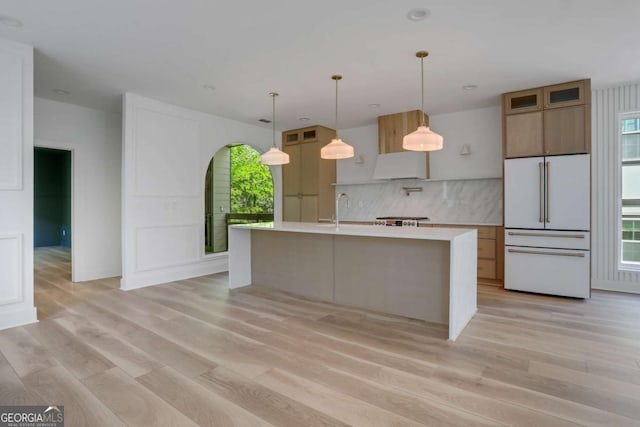644 Glendale Rd, Scottdale, GA 30079 - kitchen featuring light countertops, freestanding refrigerator, light wood-type flooring, a kitchen island with sink, and backsplash