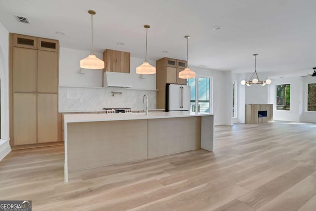 644 Glendale Rd, Scottdale, GA 30079 - kitchen featuring light wood finished floors, a large island with sink, light countertops, visible vents, and freestanding refrigerator