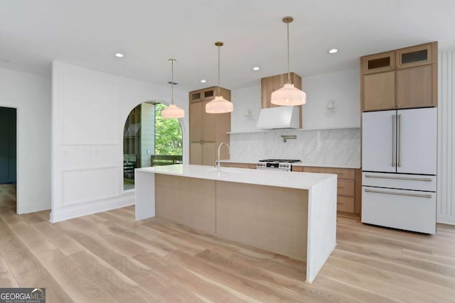 644 Glendale Rd, Scottdale, GA 30079 - kitchen featuring freestanding refrigerator, light wood-style flooring, ventilation hood, light countertops, and decorative backsplash