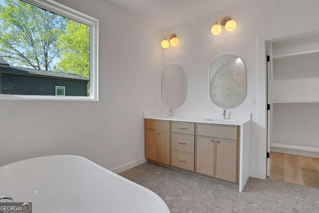 644 Glendale Rd, Scottdale, GA 30079 - full bathroom with a freestanding bath, double vanity, baseboards, and a sink