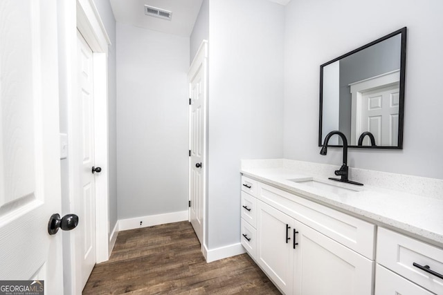 bathroom featuring wood finished floors, vanity, baseboards, and visible vents