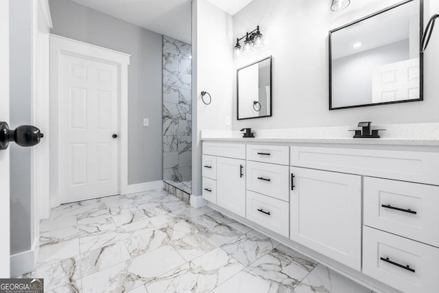 bathroom featuring marble finish floor, a sink, a marble finish shower, double vanity, and baseboards