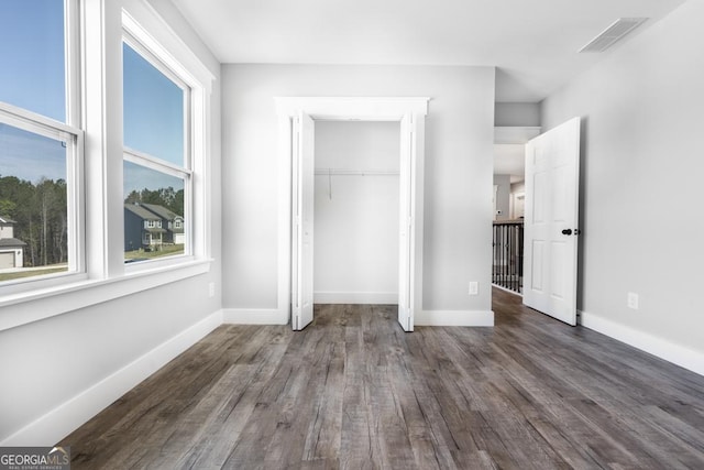 unfurnished bedroom with visible vents, baseboards, a closet, and wood finished floors