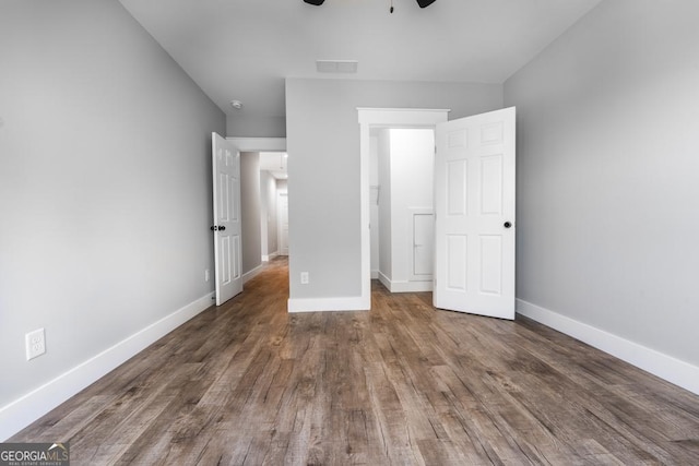 unfurnished bedroom featuring visible vents, baseboards, a ceiling fan, and wood finished floors