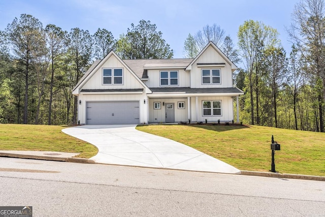 view of front of home with concrete driveway, a front yard, board and batten siding, and a garage