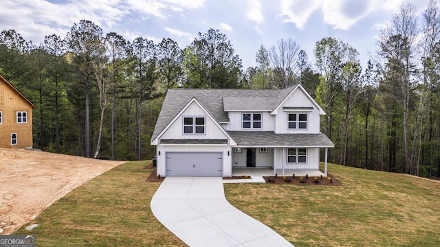 view of front of house featuring board and batten siding, a porch, roof with shingles, a front yard, and driveway