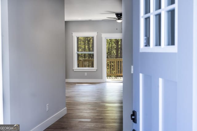 interior space featuring dark wood-type flooring, baseboards, and a ceiling fan