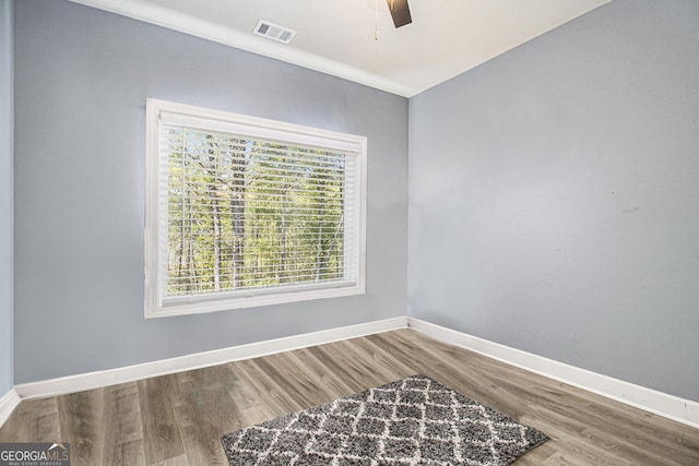 bedroom featuring wood finished floors, visible vents, and a ceiling fan