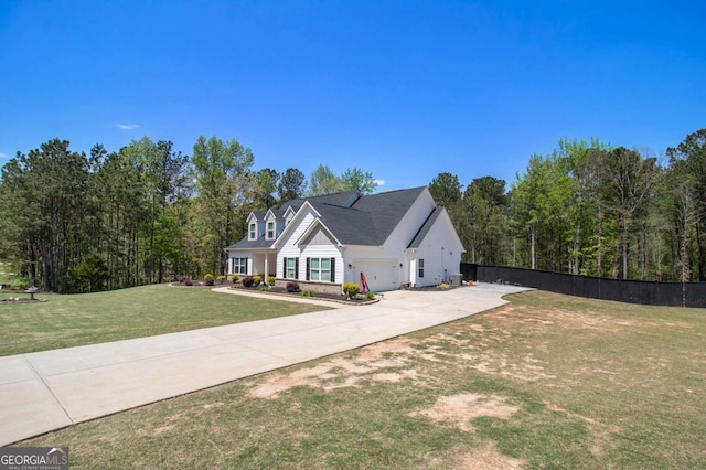 view of front facade with fence, a front lawn, driveway, and a garage