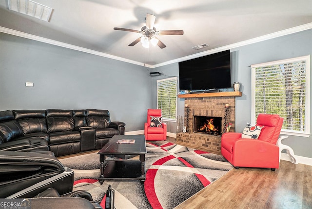 living room featuring baseboards, a ceiling fan, visible vents, and a brick fireplace