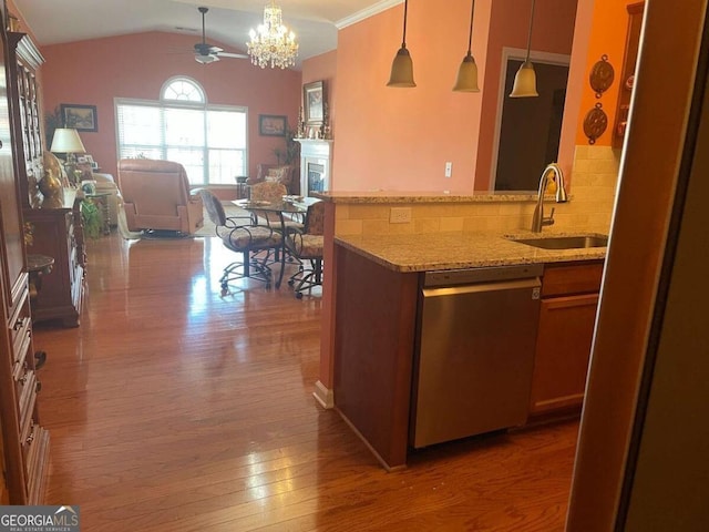 kitchen featuring a sink, open floor plan, ceiling fan with notable chandelier, stainless steel dishwasher, and hardwood / wood-style floors