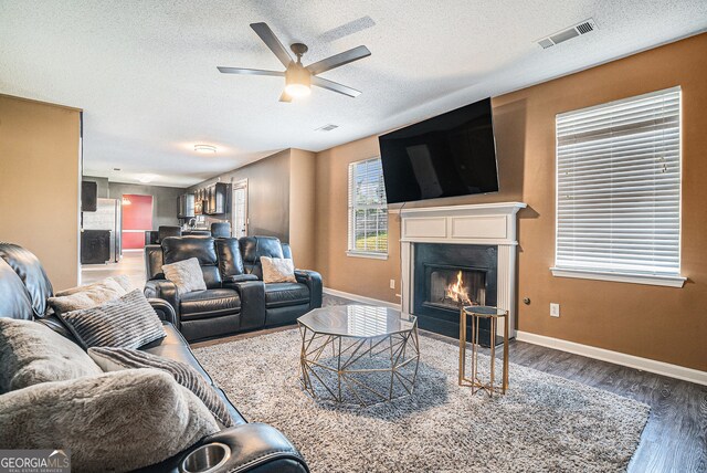 4180 W Stubbs Rd, College Park, GA 30349 - living room with ceiling fan, a textured ceiling, visible vents, and wood finished floors