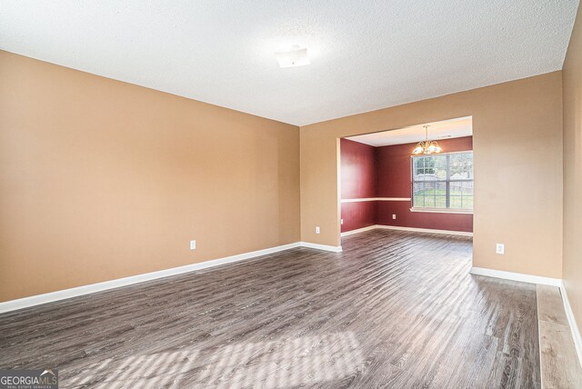 4180 W Stubbs Rd, College Park, GA 30349 - spare room featuring a notable chandelier, dark wood finished floors, and baseboards