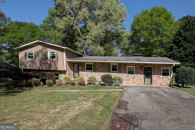 split level home with aphalt driveway, a front yard, and brick siding