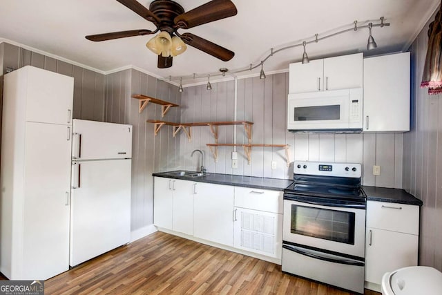 kitchen featuring white appliances, open shelves, a sink, dark countertops, and light wood finished floors