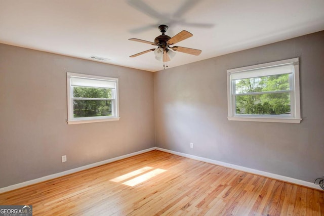 unfurnished room featuring baseboards, visible vents, and plenty of natural light