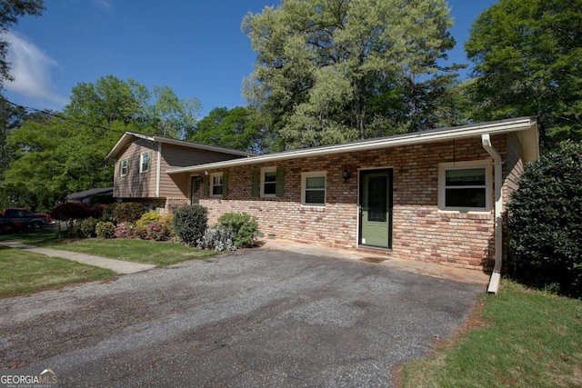 tri-level home featuring a front lawn and brick siding
