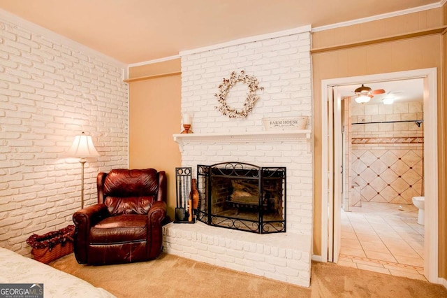 sitting room featuring crown molding, brick wall, carpet flooring, and a brick fireplace