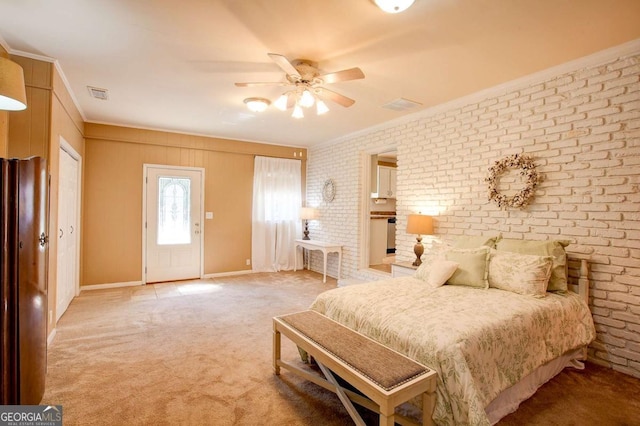 carpeted bedroom with visible vents, ornamental molding, multiple closets, and brick wall