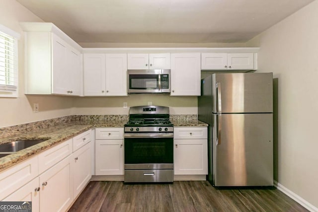 2304 Ousley Ct, Decatur, GA 30032 - kitchen with dark wood-type flooring, white cabinets, appliances with stainless steel finishes, and light stone countertops