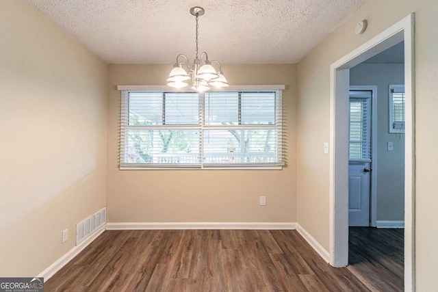 2304 Ousley Ct, Decatur, GA 30032 - unfurnished dining area with a chandelier, dark wood-type flooring, visible vents, and a textured ceiling