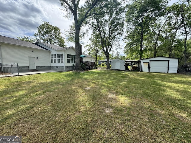 126 Patrick St, Swainsboro, GA 30401 - view of yard featuring an outdoor structure, a storage unit, a garage, and fence