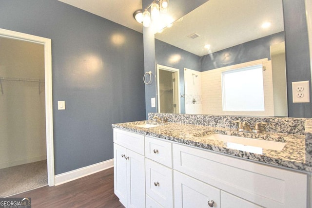 191 Fairview Oak Trl, Dallas, GA 30157 - full bath with double vanity, a walk in closet, and wood finished floors
