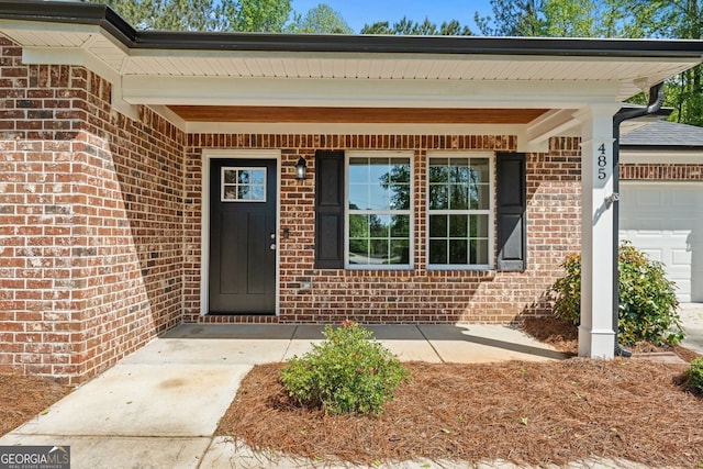 485 Swint Rd, Griffin, GA 30224 - view of exterior entry with brick siding, an attached garage, and a porch