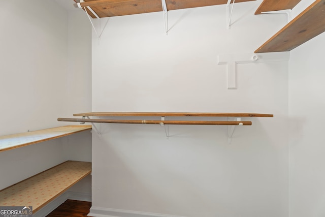 spacious closet with attic access and wood finished floors
