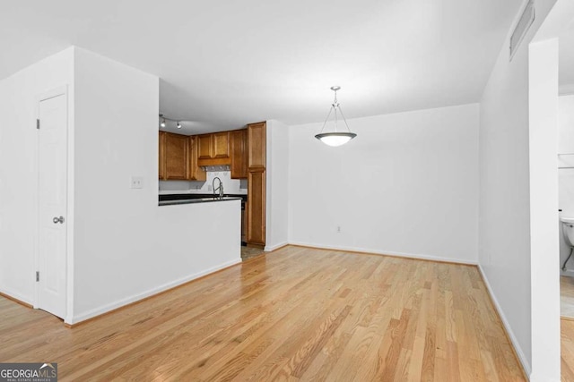 1468 Briarwood Rd NE Unit 602, Atlanta, GA 30319 - unfurnished living room with light wood finished floors, baseboards, and a sink