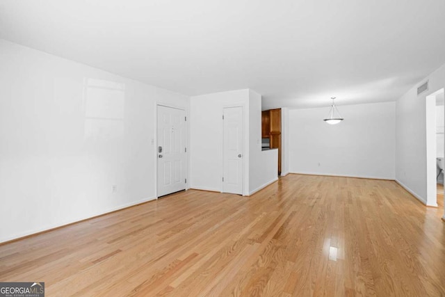 1468 Briarwood Rd NE Unit 602, Atlanta, GA 30319 - unfurnished living room featuring light wood-style flooring, baseboards, and visible vents