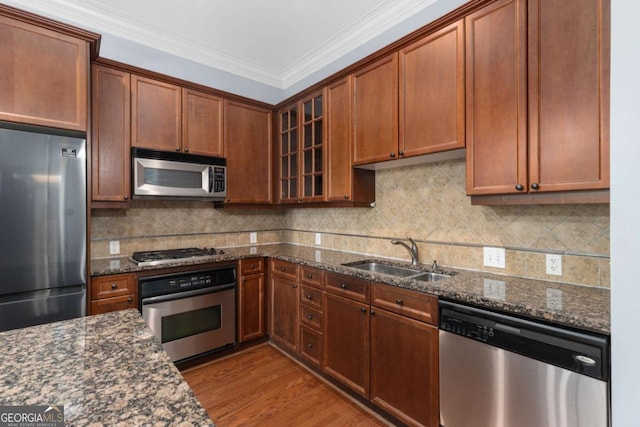 11 Perimeter Ctr E Unit 1404, Atlanta, GA 30346 - kitchen featuring stainless steel appliances, dark stone countertops, glass insert cabinets, ornamental molding, and wood finished floors