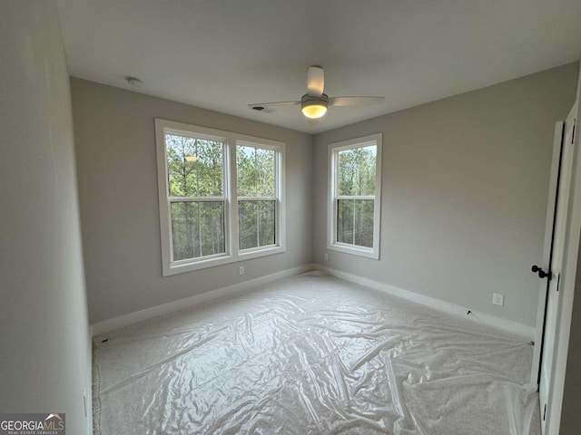 spare room featuring baseboards, a ceiling fan, and visible vents