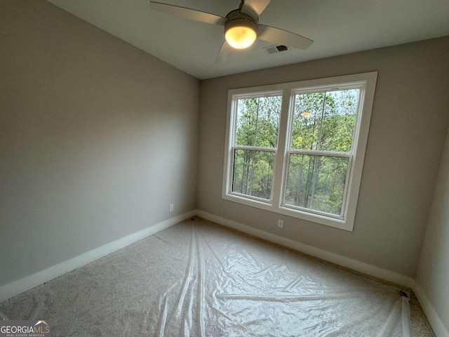 empty room with visible vents, baseboards, a ceiling fan, and carpet flooring