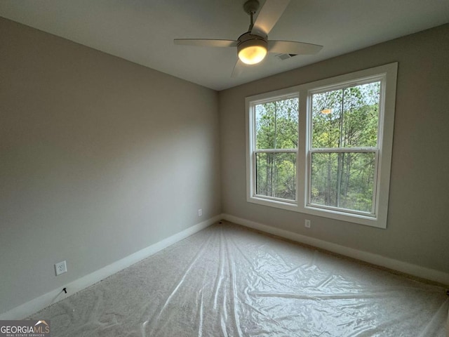 carpeted spare room with ceiling fan, baseboards, and visible vents