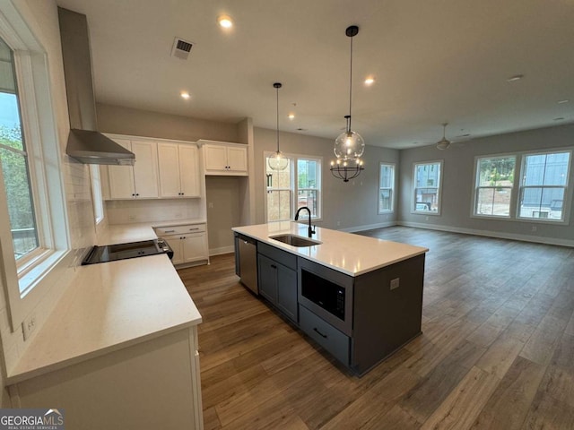 kitchen with black / electric stove, built in microwave, dark wood finished floors, stainless steel dishwasher, and a sink