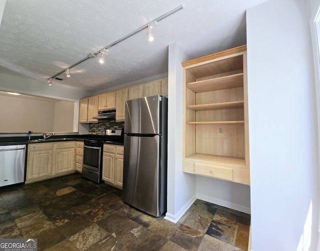 kitchen featuring appliances with stainless steel finishes, light brown cabinets, rail lighting, and under cabinet range hood