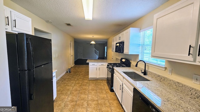 kitchen featuring a peninsula, a sink, white cabinets, visible vents, and black appliances