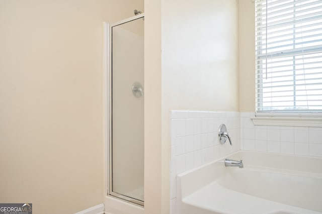 bathroom featuring a garden tub and a stall shower
