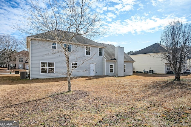 back of house with cooling unit and a chimney